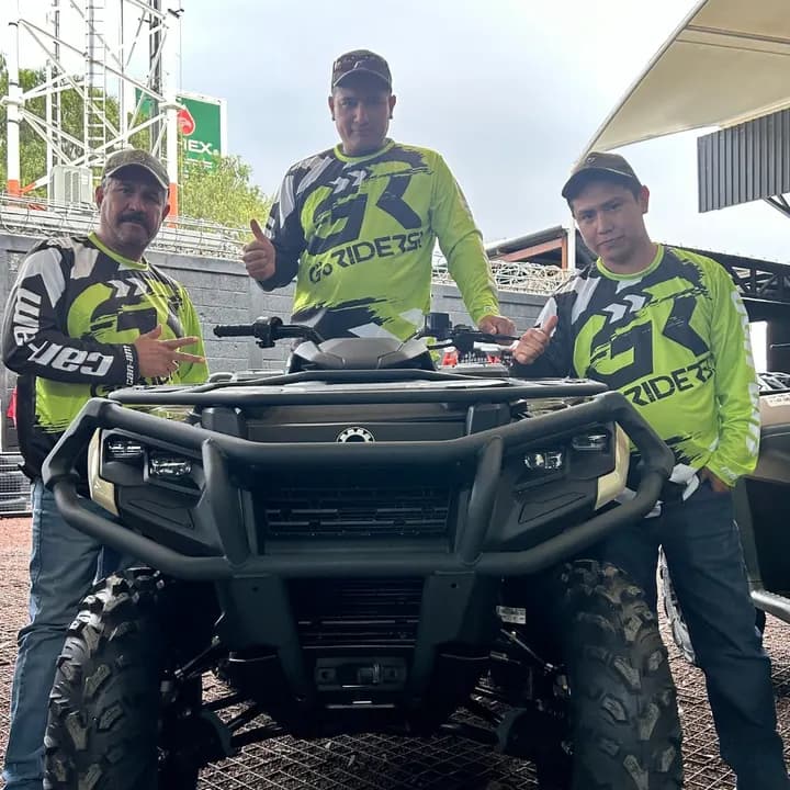 Tres clientes con la camiseta de Go Riders detrás de su cuatrimoto