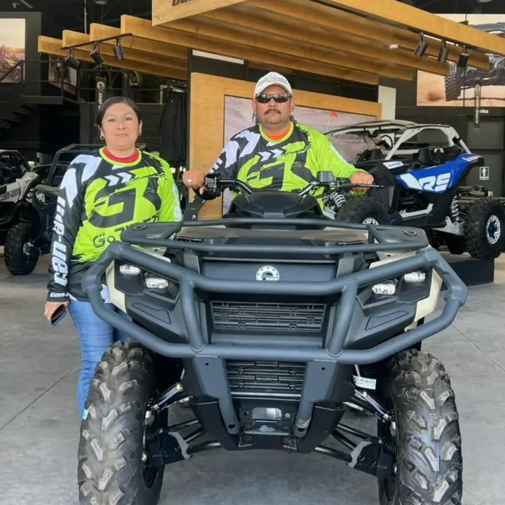 Una pareja de clientes con la camiseta de Go Riders sobre su cuatrimoto Can-Am