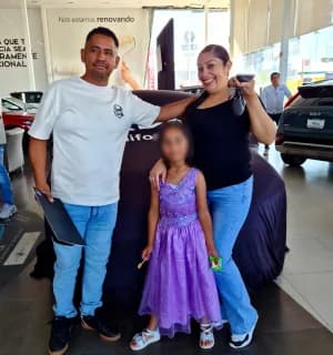 Una familia con su KIA cubierto durante la entrega