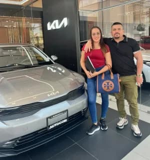 Una pareja con su KIA gris en la sucursal