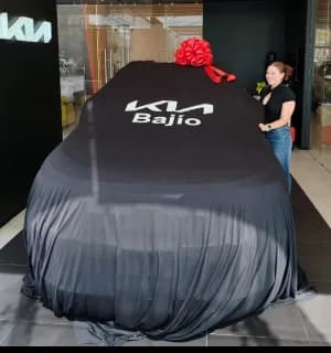 Un KIA cubierto con la lona de la sucursal