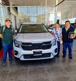 Clientes con su KIA blanco en la sucursal
