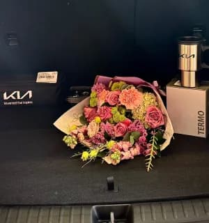 Un ramo de flores en la cajuela de un KIA durante la entrega