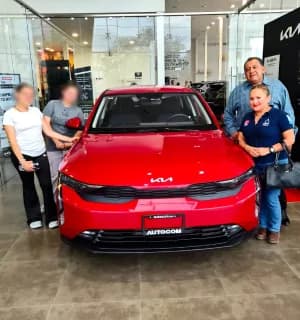 Clientes con su KIA rojo en la sucursal