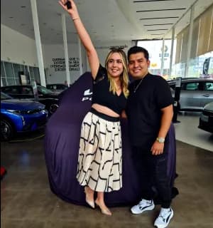 Una pareja celebrando junto a un KIA cubierto